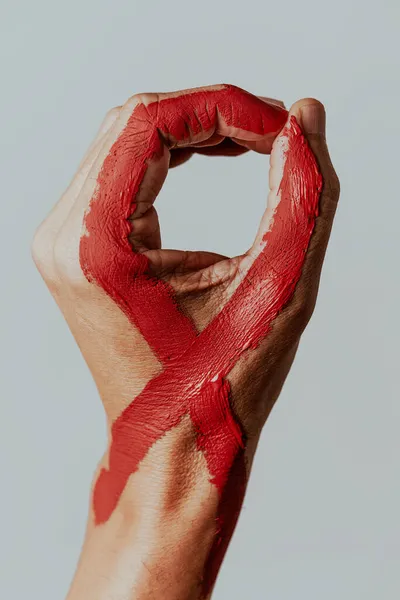 Κοντινό Πλάνο Του Χεριού Ενός Άνδρα Μια Κόκκινη Κορδέλα Ευαισθητοποίησης — Φωτογραφία Αρχείου