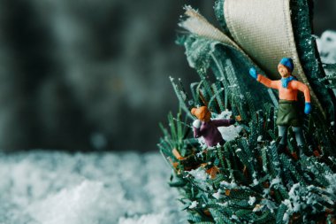 Birkaç minyatür insanın sahte karla oynadığı, solunda boş bir alan olan yakın plan.