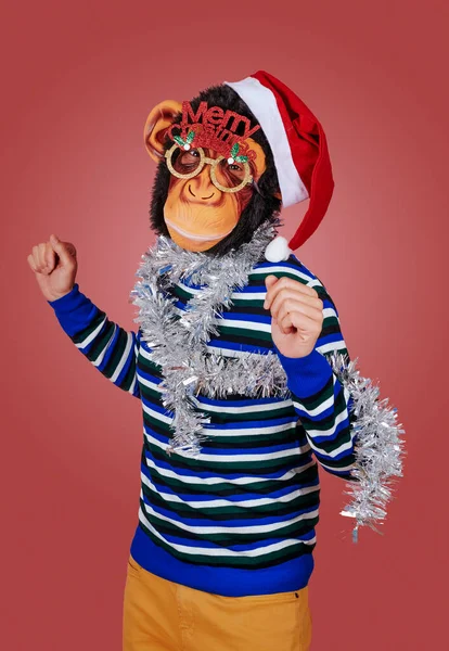 남자가 원숭이 마스크를 모자를 성탄절을 축하하는 문장이 새겨진 안경을 배경에는 — 스톡 사진