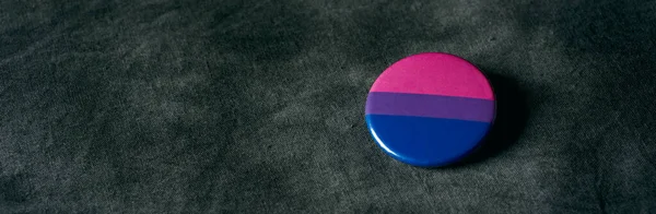 一种带有双性恋骄傲旗的徽章 用深灰色染布制成 全景格式 可用作网页横幅或头饰 — 图库照片