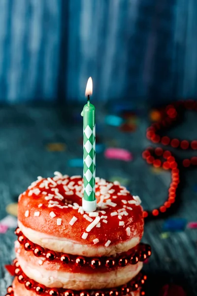 Closeup Lit Candle Top Pile Donuts Covered Red Frosting Gray — Stockfoto