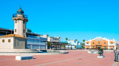 Castello, İspanya - 17 Ocak 2022: İspanya 'nın El Grau kentinde bulunan Castello de la Plana limanındaki Moll de Costa rıhtımında gezinti alanı, eski deniz fenerini vurguluyor.