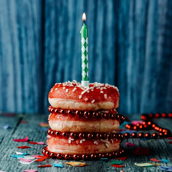 Closeup Lit Green White Candle Top Pile Donuts Red Frosting — Stock Photo, Image