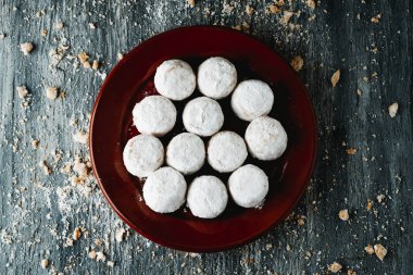 Mantecados nevados kaplı bir tabağın yüksek açılı görüntüsü, şekerle kaplı İspanyol kısa ekmeği, tipik olarak Noel 'de gri bir ahşap masada yenir.