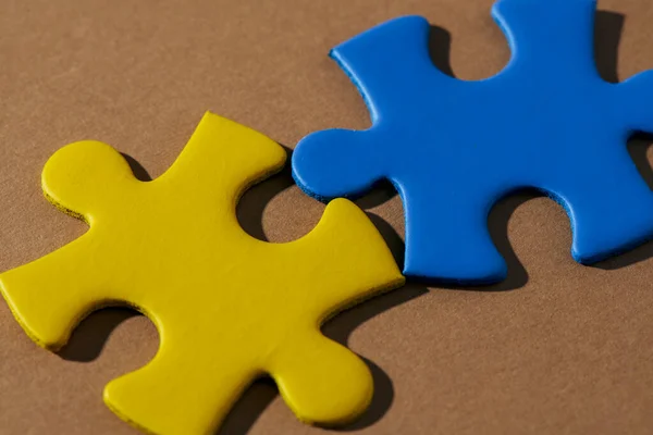 Twee Legpuzzelstukjes Met Kleuren Van Oekraïense Vlag Een Bruine Achtergrond — Stockfoto