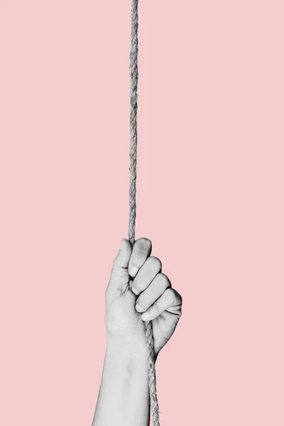 a young man pulling a rope in black and white, on a pink background