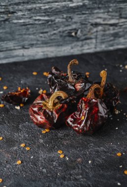 Bir çok geleneksel İspanyol tarifinde kullanılan kurutulmuş Nora biberi desenli taş bir yüzey üzerinde.