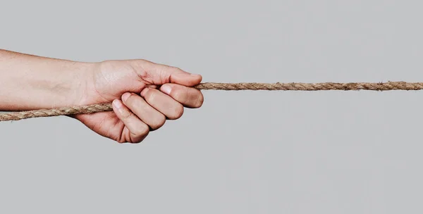 Closeup Caucasian Man Pulling Rope Pale Gray Background Panoramic Format — Stock Photo, Image