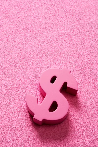 a pink dollar sign on a pink background with some blank space on top, to depict the pink money or pink capitalism concepts