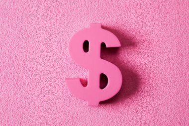 closeup of a pink dollar sign on a textured pink background, depicting the pink money or pink capitalism concepts clipart