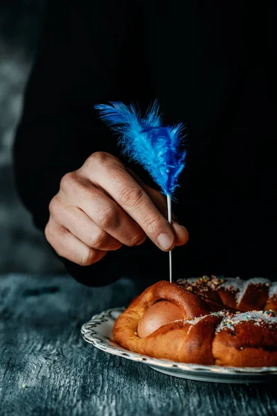 Мужчина Украшает Голубым Пером Традиционную Испанскую Мону Паскуа Торт Съеденный — стоковое фото