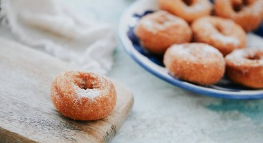İçinde Rosquillas olan bir tabak, tipik İspanyol çörekleri üzerine şeker serpiştirilmiş, panoramik bir formatta, web pankartı olarak kullanılacak.