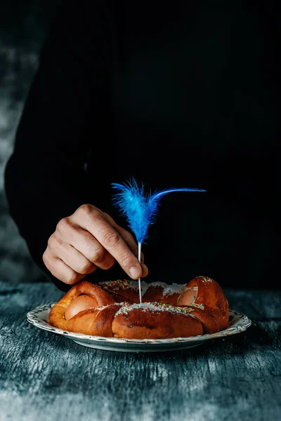 Мужчина Украшает Голубым Пером Традиционный Испанский Пирог Мона Паскуа Съеденный — стоковое фото