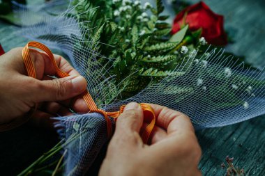 Katalan bayrağıyla desenli kurdeleli bir erkek bağları, kırmızı güllü bir buket Aziz George Günü 'nün Katalanca adı Aziz Jordi için, İspanya Katalonya' da kırmızı güller vermek gelenektir.