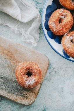 Rosquilla 'nın yüksek açısı, tipik bir İspanyol çöreği şekerle serpiştirilmiş, beyaz ve mavi seramik tabağın yanında biraz daha ev yapımı rosquillas.