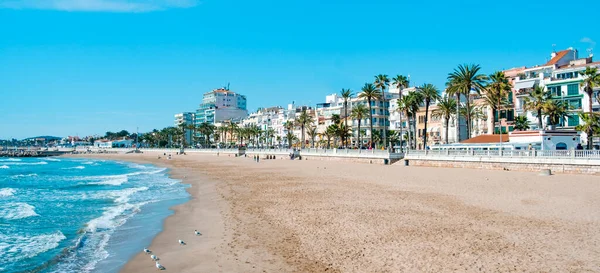 Sitges, İspanya - 3 Mart 2022: İspanya 'nın Platja de la Fragata plajının panoramik manzarası, kıyı şeridinde birçok restoran ve otelin bulunduğu yerleşim alanı