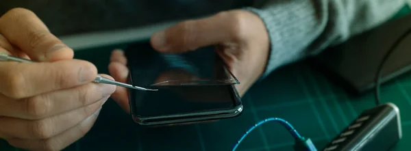 Closeup Man Removing Broken Screen Protector Smartphone Sitting Table Worktop — стоковое фото
