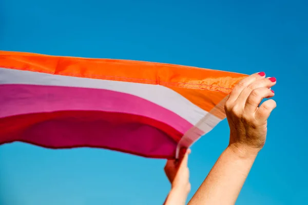 在天空中 一个高举女同性恋骄傲旗的高加索女人的手在头顶上的特写 — 图库照片