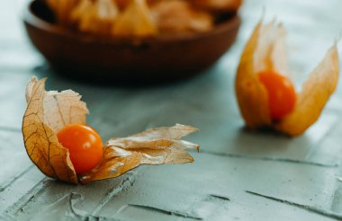 Kabuklarında olgunlaşmış toprak kirazlarının dokusu gri bir yüzeye yakın çekim.