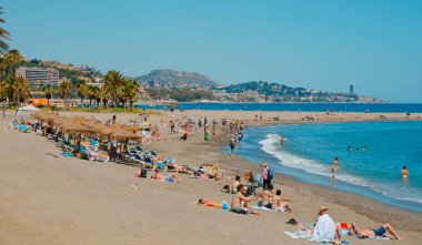 Malaga, İspanya - 26 Mayıs 2022: İspanya 'nın Malaga kentindeki La Malagueta plajında güneşli bir bahar gününün tadını çıkaran birçok insan
