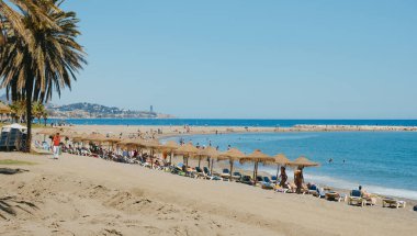 Malaga, İspanya - 26 Mayıs 2022: İspanya 'nın Malaga kentindeki popüler La Malagueta plajı üzerinde güneşli bir bahar gününün güzel havasının keyfini çıkaran bir panoramik manzara