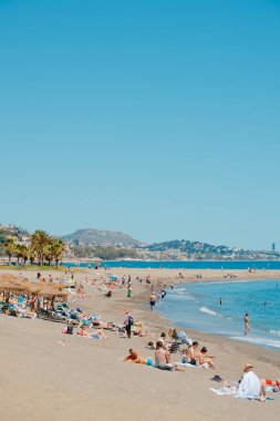 Malaga, İspanya - 26 Mayıs 2022: İspanya 'nın Malaga kentindeki popüler La Malagueta plajında güneşli bir bahar gününün tadını çıkaran insanlar