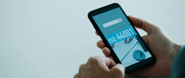 Homem Escritório Segurando Seu Smartphone Que Texto Iso 44001 Sua — Fotografia de Stock