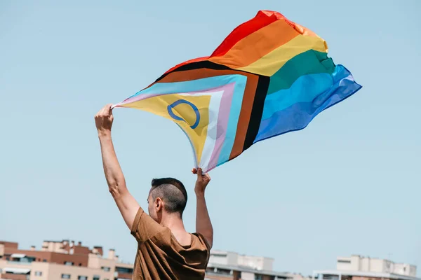 街上的一个男人在空中挥动着双性包容的进步的骄傲 — 图库照片