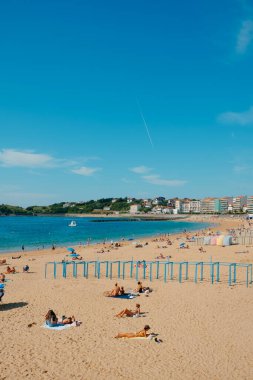 Saint-Jean-de-Luz, Fransa - 24 Haziran 2022: İnsanlar Saint-Jean-de-Luz, Fransa 'da La Grande Plage plajında güzel havanın tadını çıkarıyorlar.