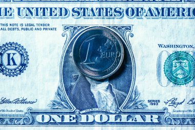 İki para birimi arasındaki eşitliği gösteren bir Amerikan doları banknotuna 1 avroluk bir madeni paranın yakın plan çekimleri