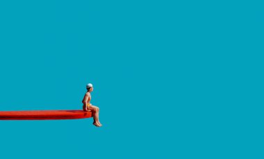 a miniature man, wearing a yellow swimsuit and a white swimming cap, sits on the edge of a red diving board, on a blue background with some blank space around