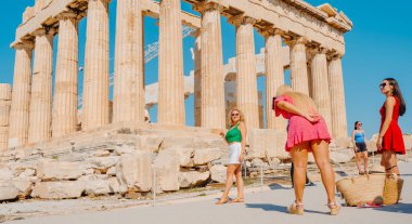 Atina, Yunanistan - 30 Ağustos 2022: Yunanistan 'ın Akropolis kentindeki ünlü Parthenon' un kalıntıları önünde genç bir bayan poz veriyor