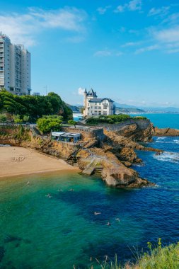 Biarritz, Fransa - 24 Haziran 2022: Bazı insanlar sabahın erken saatlerinde Biarritz, Fransa 'daki Plage du Port Vieux plajında suyun tadını çıkarıyorlar