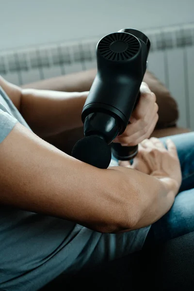 Een Jonge Blanke Man Gebruikt Een Massagepistool Spieren Van Zijn — Stockfoto