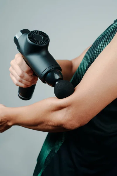 Een Jonge Kaukasische Sportman Draagt Sportkleding Gebruikt Een Massagepistool Spieren — Stockfoto