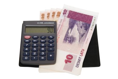 Küçük bir elektronik hesap makinesi ve beyaz arka planda izole edilmiş birkaç banknot.