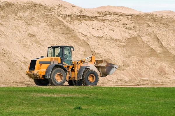 Yol çalışması için bir buldozer ve büyük bir kum dağı.