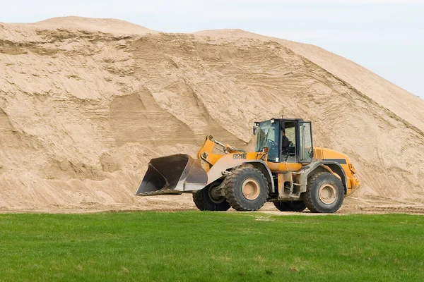 Yol çalışması için bir buldozer ve büyük bir kum dağı.