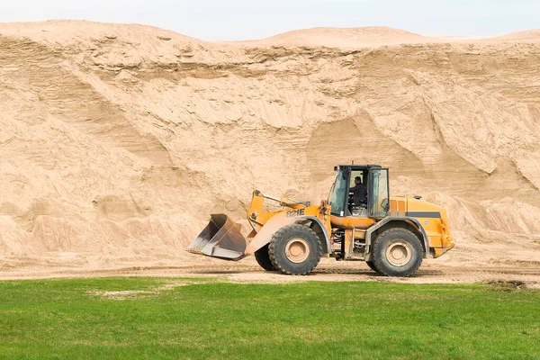 Yol çalışması için bir buldozer ve büyük bir kum dağı.