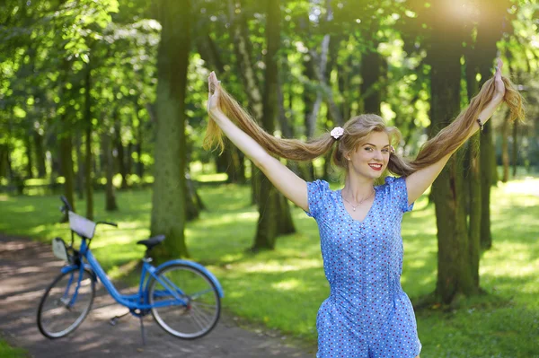 Cheveux longs. Fille drôle sur le vélo dans le parc — Photo