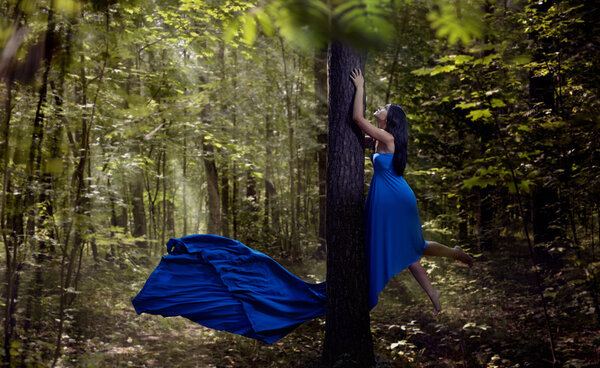 Beautiful woman flying up in forest. Magic.