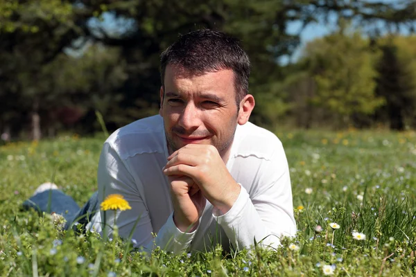 Man liggend op het gras — Stockfoto