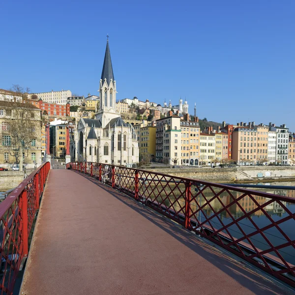 Röd gångbro och kyrkan — Stockfoto