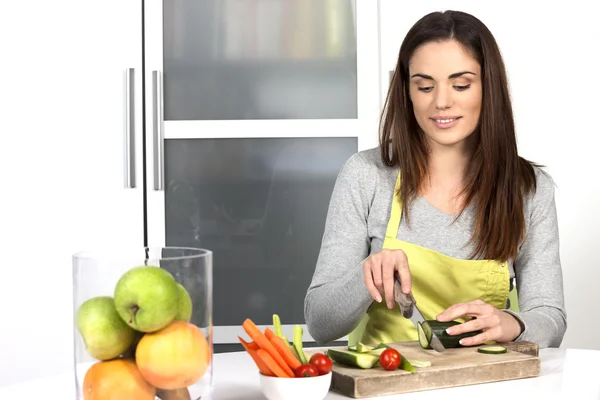 Vrouw snijden komkommer en groenten — Stockfoto