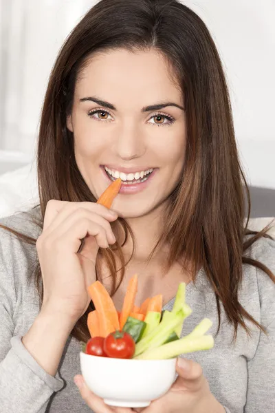 Femme sur canapé manger salade de légumes — Photo