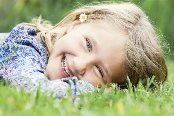 Flickan liggande på gräs skrattande — Stockfoto
