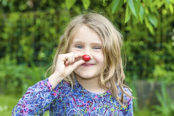 Barn med körsbär i handen — Stockfoto