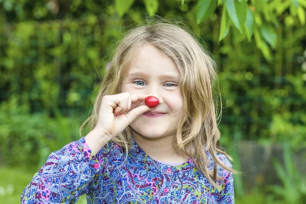 Niño con cereza en la mano Imágenes De Stock Sin Royalties Gratis