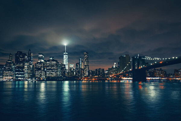 View of New York with Brooklyn bridge by night, USA.