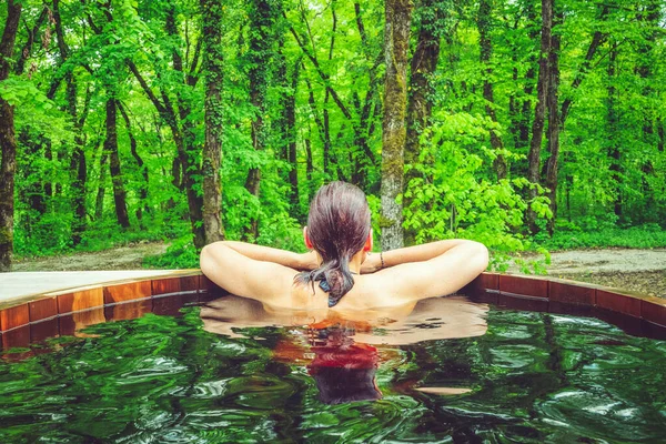 Güzel bir kadın bir ormanın önünde, İskandinav banyosunda.